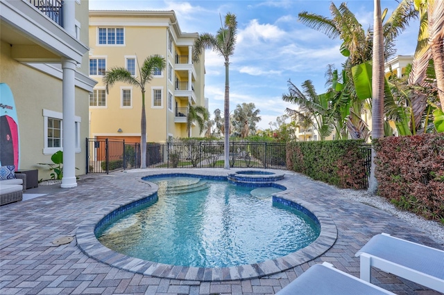 view of pool featuring an in ground hot tub and a patio