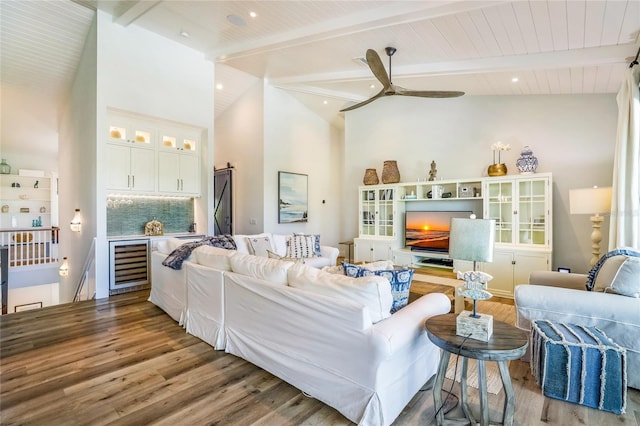 living room featuring beamed ceiling, wood-type flooring, beverage cooler, and high vaulted ceiling