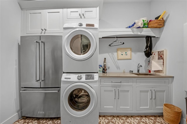 washroom featuring sink, cabinets, and stacked washing maching and dryer