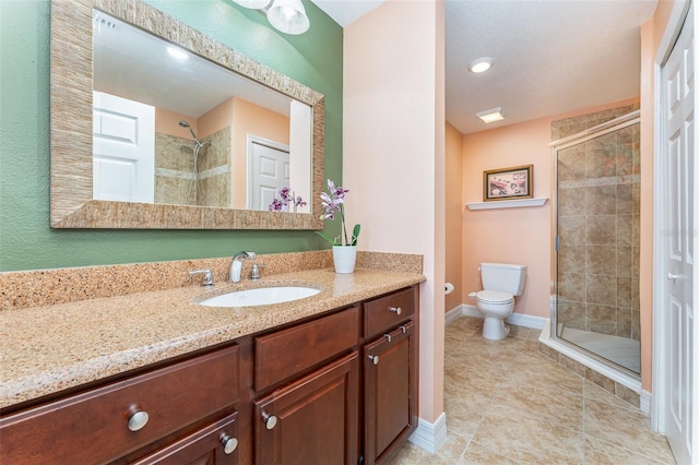 bathroom featuring tile patterned floors, vanity, toilet, and an enclosed shower