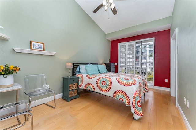 bedroom with baseboards, high vaulted ceiling, ceiling fan, and wood finished floors