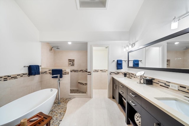 bathroom with independent shower and bath, vanity, and tile walls