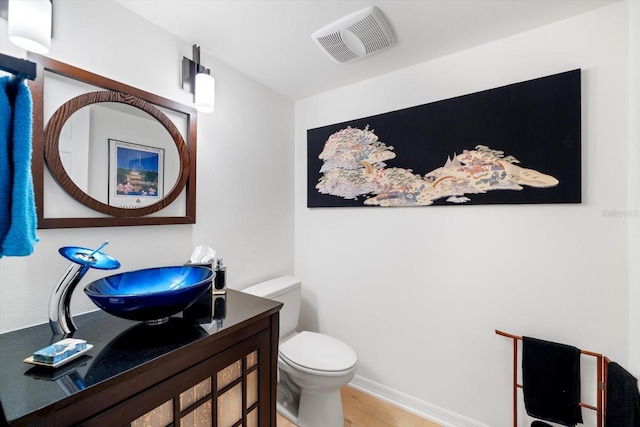 bathroom with vanity, hardwood / wood-style floors, and toilet