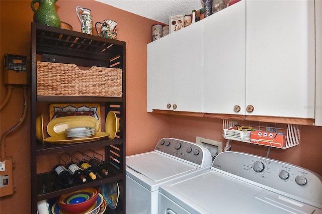 washroom featuring cabinets, separate washer and dryer, and a textured ceiling