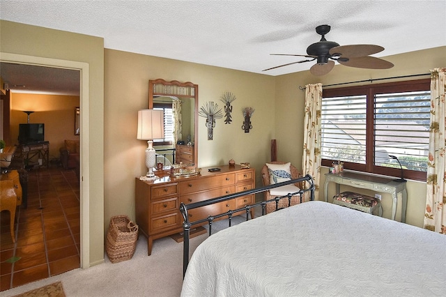 bedroom with ceiling fan, a textured ceiling, and carpet flooring