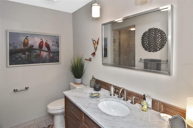 bathroom featuring vanity, toilet, and tile patterned flooring