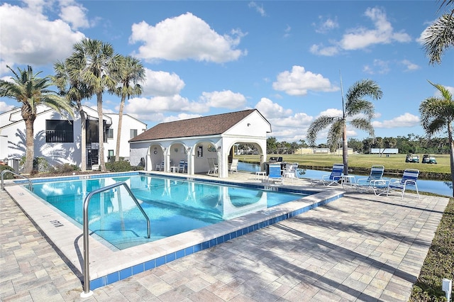 view of pool featuring a patio and a water view