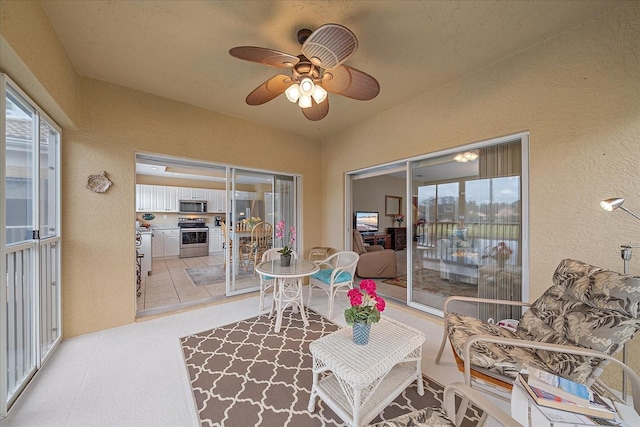 sunroom / solarium featuring ceiling fan