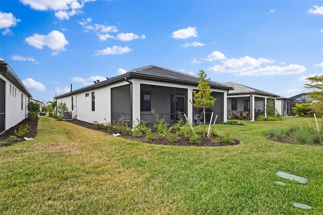 back of property featuring a sunroom, a yard, and central air condition unit