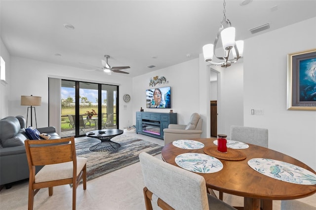 dining area featuring ceiling fan with notable chandelier