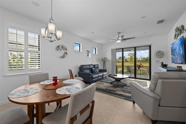 dining area with light tile patterned floors and ceiling fan with notable chandelier