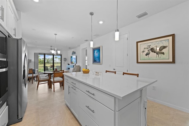 kitchen featuring appliances with stainless steel finishes, hanging light fixtures, a kitchen island, and white cabinets