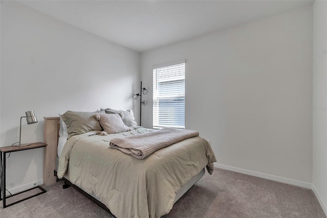 bedroom featuring carpet and baseboards