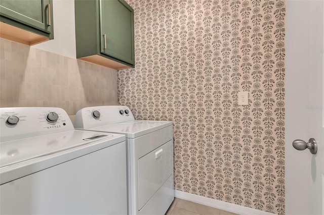 laundry room with cabinets, separate washer and dryer, light tile patterned floors, and tile walls