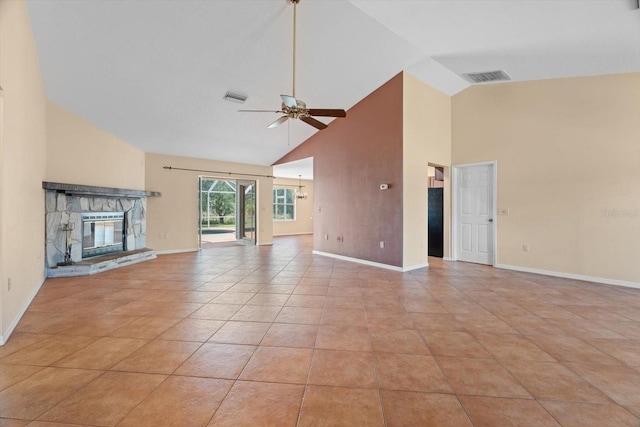 unfurnished living room with light tile patterned flooring, a stone fireplace, high vaulted ceiling, and ceiling fan