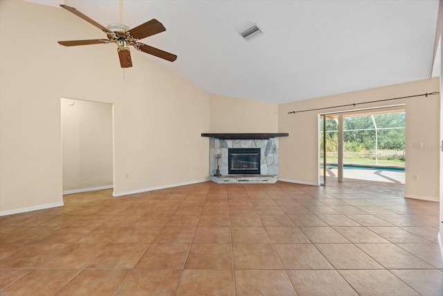 unfurnished living room featuring ceiling fan, a stone fireplace, vaulted ceiling, and light tile patterned floors