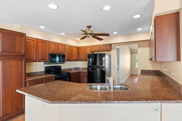 kitchen featuring sink, ceiling fan, black appliances, kitchen peninsula, and dark stone counters