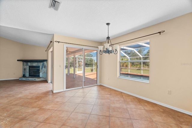 unfurnished dining area featuring a notable chandelier, a fireplace, a textured ceiling, and light tile patterned floors