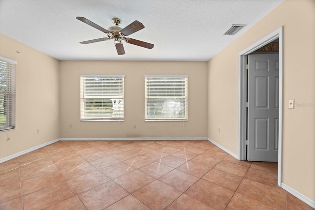 tiled empty room with a textured ceiling and ceiling fan