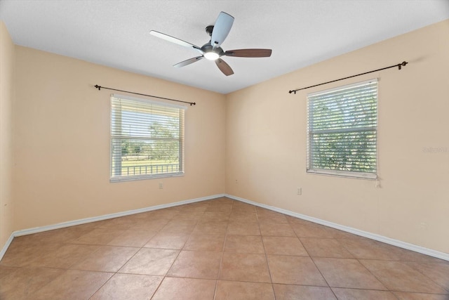 tiled spare room featuring a textured ceiling, a wealth of natural light, and ceiling fan