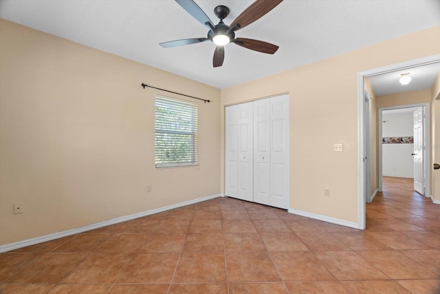 unfurnished bedroom with light tile patterned floors, a closet, and ceiling fan