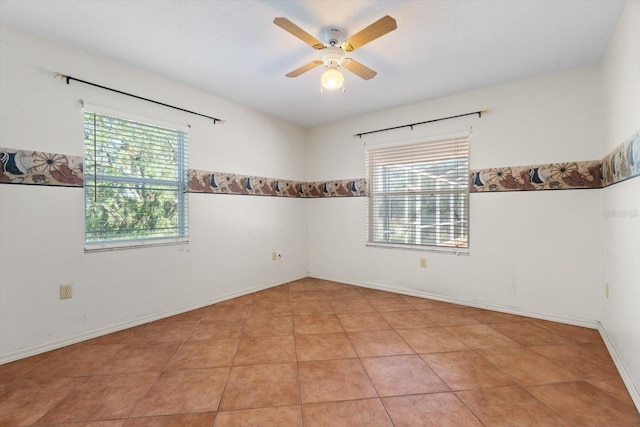 tiled spare room featuring ceiling fan