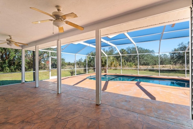 view of pool featuring ceiling fan, a patio area, glass enclosure, and a lawn