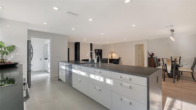 kitchen with white cabinetry, sink, a kitchen island with sink, and appliances with stainless steel finishes