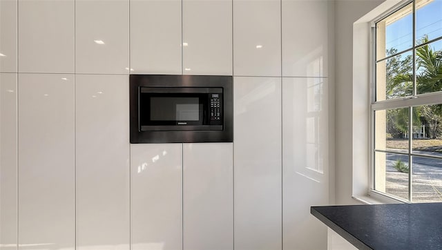 interior details with white cabinetry and stainless steel microwave