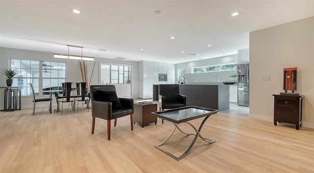 living room with sink and light hardwood / wood-style flooring