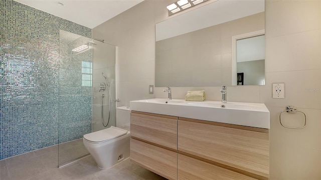 bathroom featuring tile walls, tile patterned flooring, tiled shower, vanity, and toilet