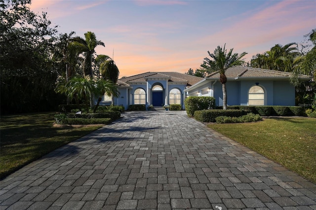 mediterranean / spanish-style house with a yard