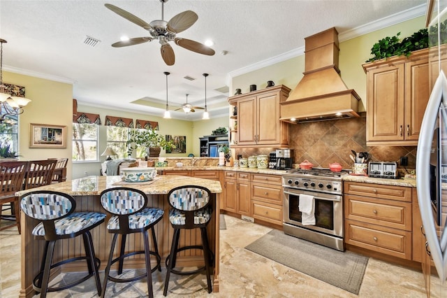 kitchen featuring decorative light fixtures, a breakfast bar area, stainless steel appliances, and custom range hood