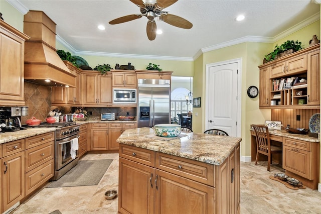 kitchen with crown molding, built in appliances, built in desk, a kitchen island, and decorative backsplash