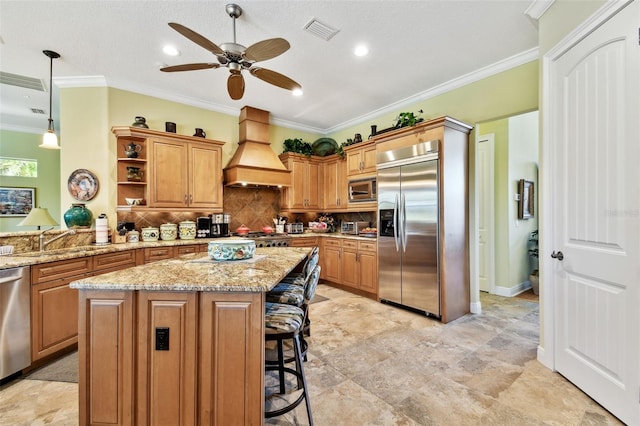 kitchen with backsplash, built in appliances, a kitchen island, decorative light fixtures, and custom exhaust hood