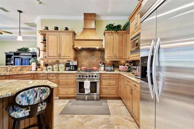 kitchen featuring pendant lighting, sink, premium range hood, backsplash, and stainless steel appliances