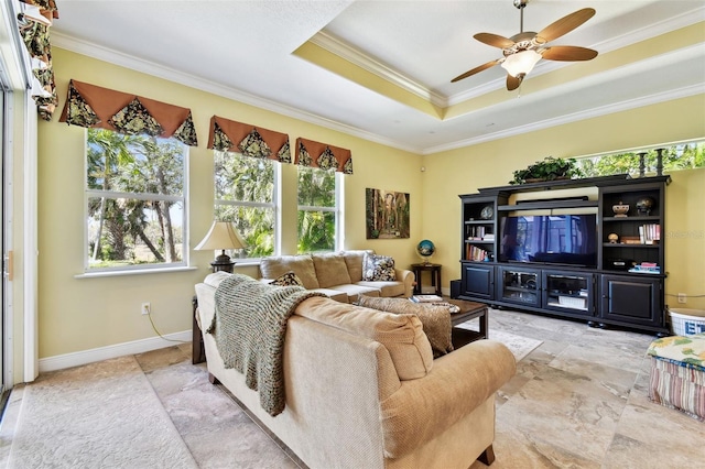 living room with ornamental molding, ceiling fan, and a tray ceiling