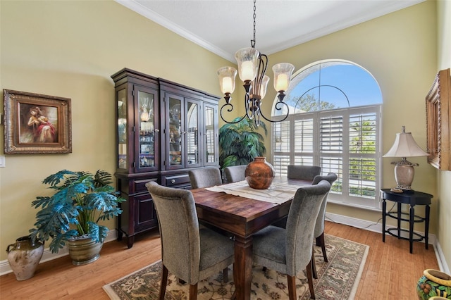 dining space with an inviting chandelier, ornamental molding, and light hardwood / wood-style floors