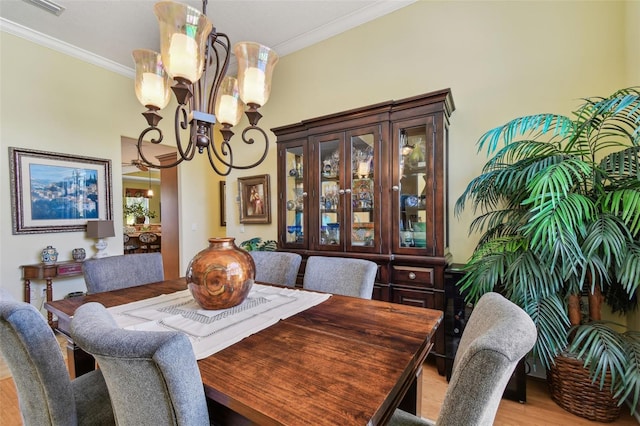 dining room with ornamental molding, light hardwood / wood-style flooring, and a notable chandelier