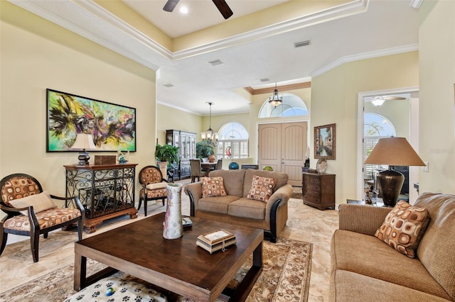 living room with crown molding, plenty of natural light, and ceiling fan with notable chandelier