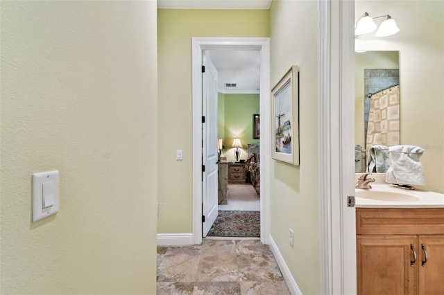 hallway featuring ornamental molding and sink