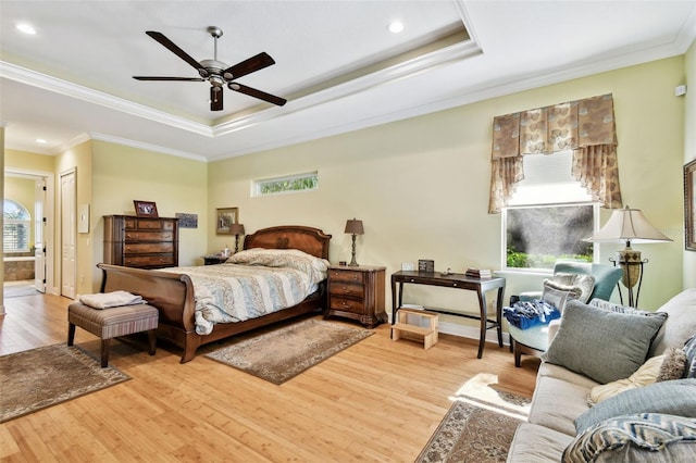 bedroom with ensuite bathroom, ornamental molding, ceiling fan, a raised ceiling, and light wood-type flooring