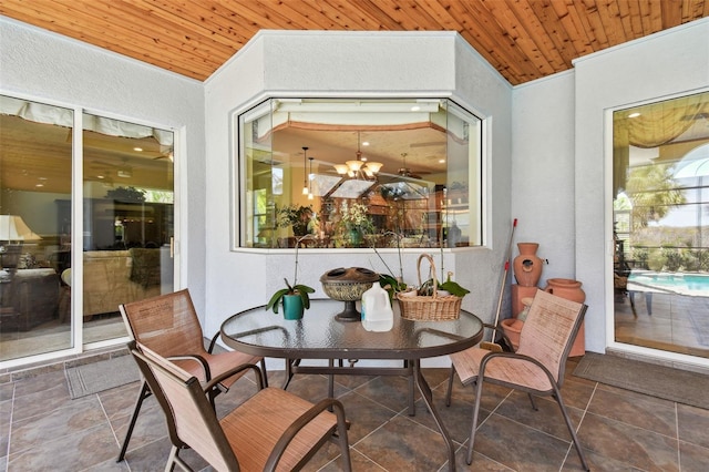 sunroom featuring wooden ceiling and an inviting chandelier