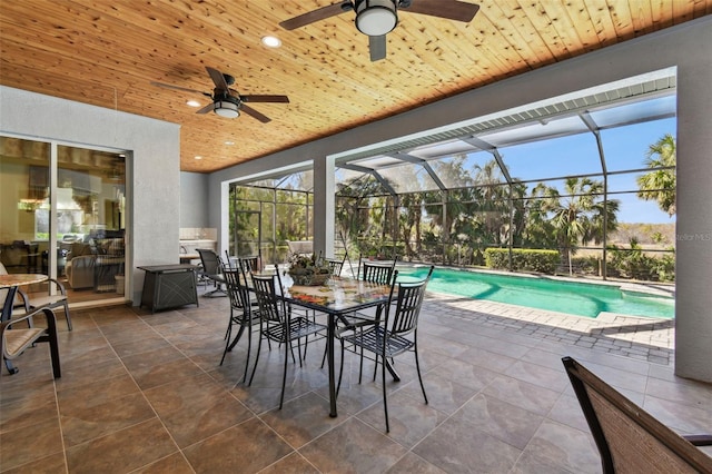 view of swimming pool with a patio, ceiling fan, and glass enclosure