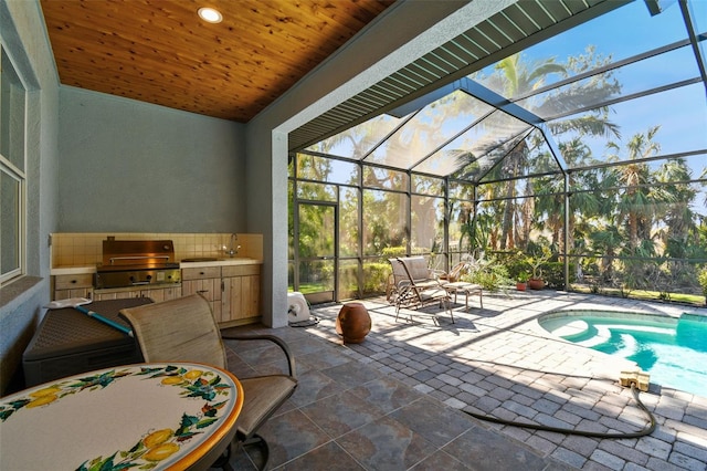 view of patio / terrace with an outdoor kitchen, sink, grilling area, and a lanai