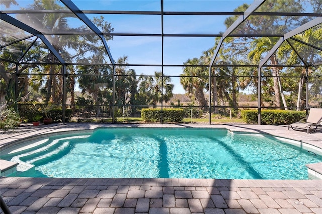 view of swimming pool featuring a patio and a lanai