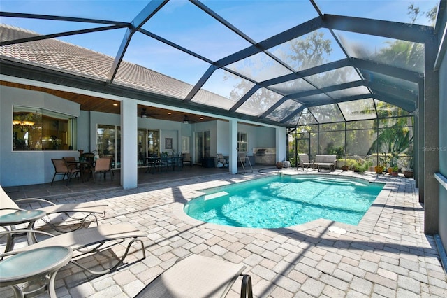 view of pool featuring a patio area, ceiling fan, and glass enclosure