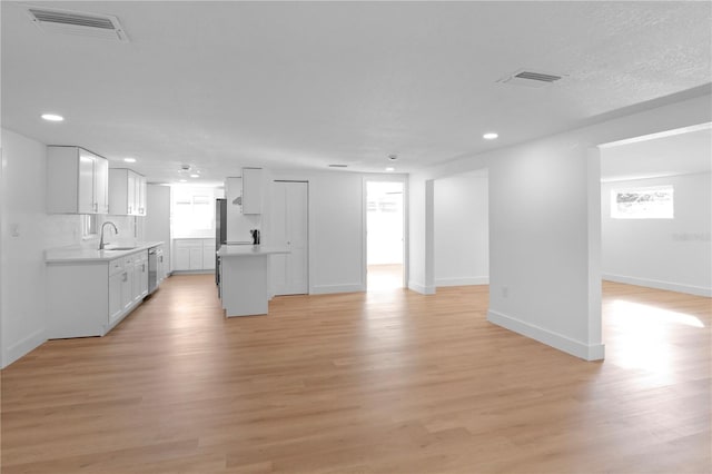 unfurnished living room with sink and light wood-type flooring