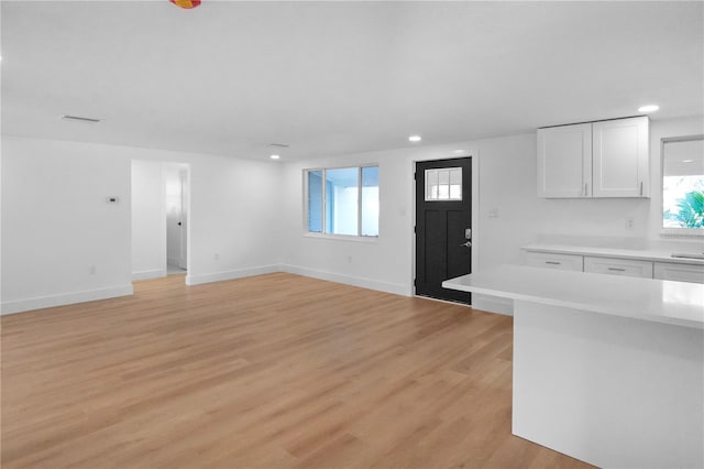 kitchen with white cabinetry and light hardwood / wood-style flooring