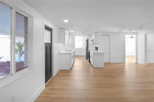 kitchen featuring white cabinetry, sink, light hardwood / wood-style flooring, and stainless steel appliances